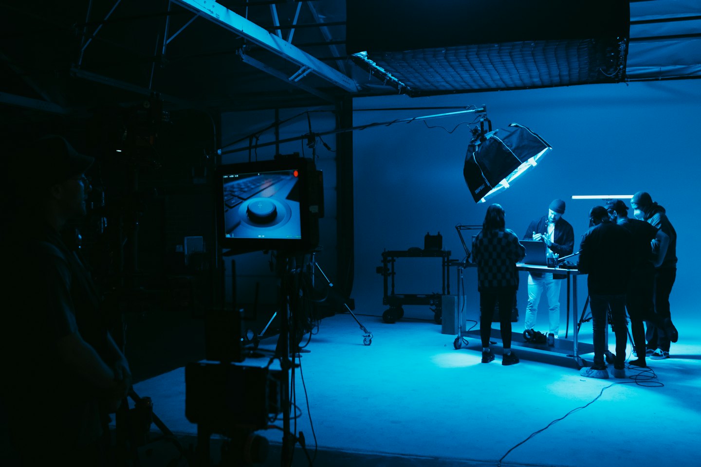 Media production professionals collaborating around a table with a laptop.